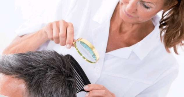 the doctor examines psoriasis on the head